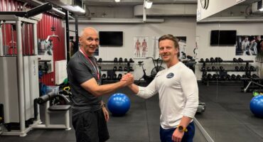 Podopieczny Body Movement z medalem za osiągnięcia sportowe obok trenera w studiu treningu personalnego w Warszawie na Mokotowie