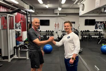 Podopieczny Body Movement z medalem za osiągnięcia sportowe obok trenera w studiu treningu personalnego w Warszawie na Mokotowie
