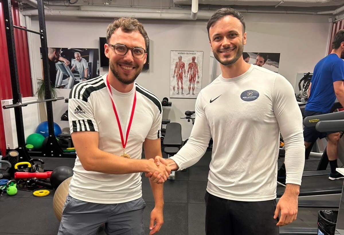 Zdjęcie Dymytro z trenerem Jakubem: Dymytro z trenerem Jakubem podczas treningu personalnego 1:1 w Body Movement. Regularna praca nad siłą i sprawnością przełożyła się na mierzalny progres siłowy.